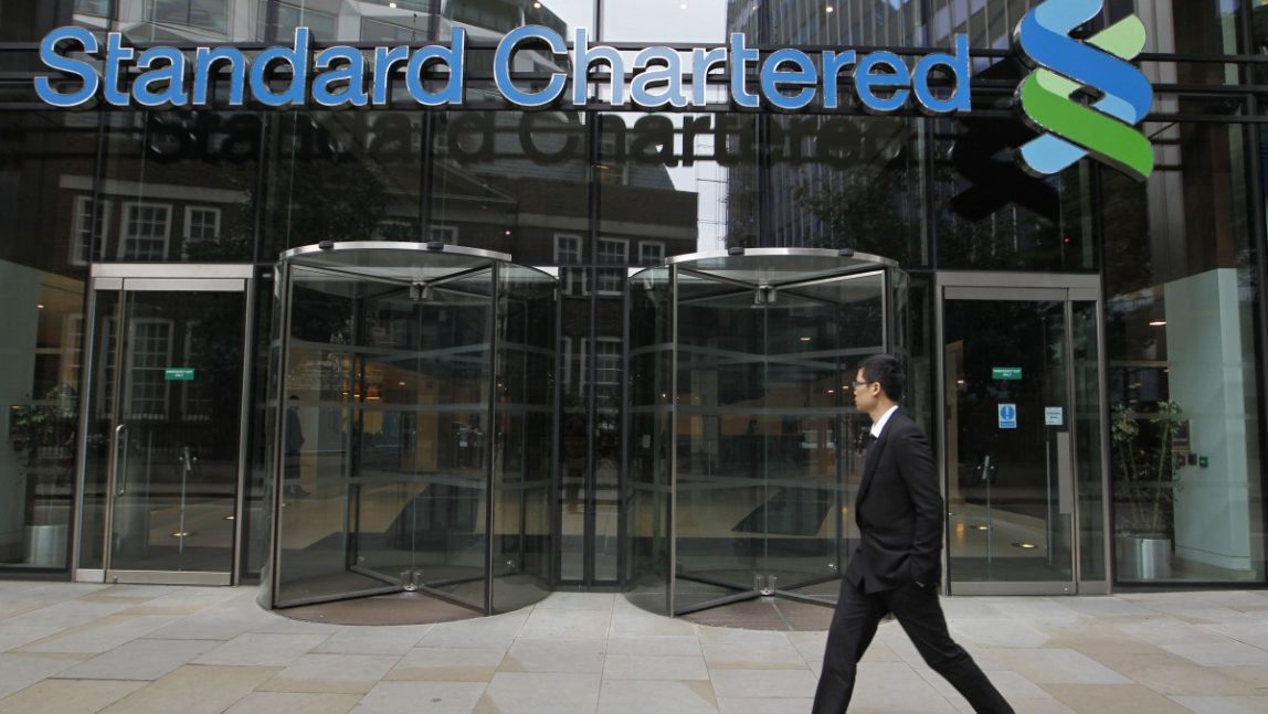 A man walks by the headquarter of Standard Chartered bank in the City of London, Tuesday, Aug. 7, 2012. (AP Photo/Sang Tan)