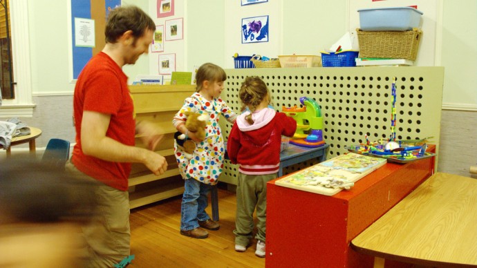 a-childcare-worker-sits-with-children-at-a-daycare-center-photo-by-pete-doviende-via-flikr