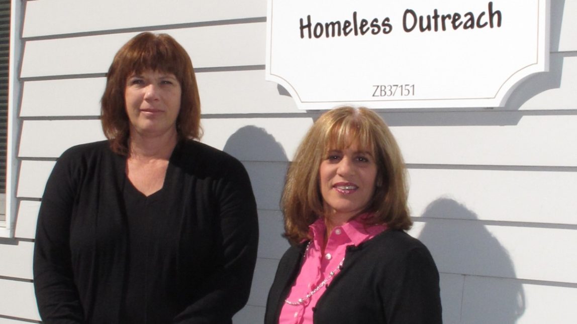 In this Oct. 11, 2012 photo, Tracey Lutz, left, executive director of the Maureen's Haven homeless outreach program, and Joann Piche, chairwoman of the board of directors, stand outside the Long Island charity's headquarters in Riverhead, N.Y. In one of the richest communities on the tony end of Long Island, a group of churches work together to provide shelter for 50-60 homeless people each night. (AP Photo/Frank Eltman)