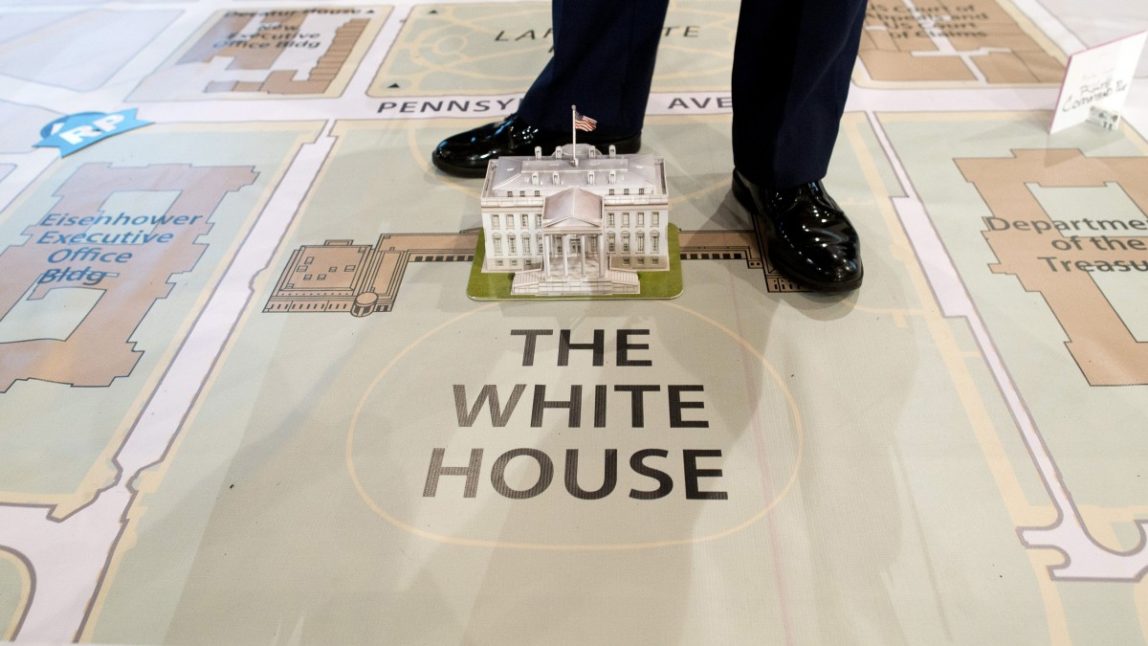 A member of Joint Task Force-National Capital Region stands over a model of the White House on a giant map during a media tour highlighting inaugural preparations being made by military and civilian planners, Wednesday, Dec. 12, 2012, at the DC Armory in Washington. (AP Photo/ Evan Vucci)