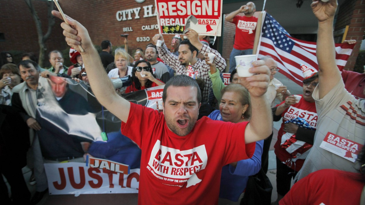 This Sept. 21, 2010 file photo shows Jesus Casas, a member of the Bell Association to Stop The Abuse, or BASTA, which also means "enough" in Spanish, joining other residents of the city of Bell, Calif., celebrating the arrest of current and former city officials on corruption charges, outside City Hall. (AP Photo/Reed Saxon, File)