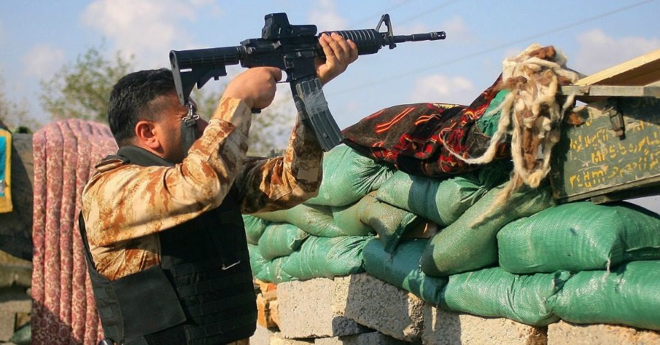 A combatant with a Shiite militant group known as Jihad Brigades fires his weapon outside of Tikrit, Iraq on Saturday. (Photo: AP)