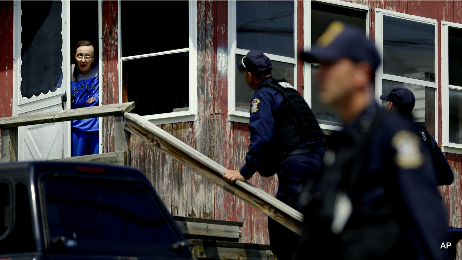 Law enforcement officers question a woman about escaped prisoners