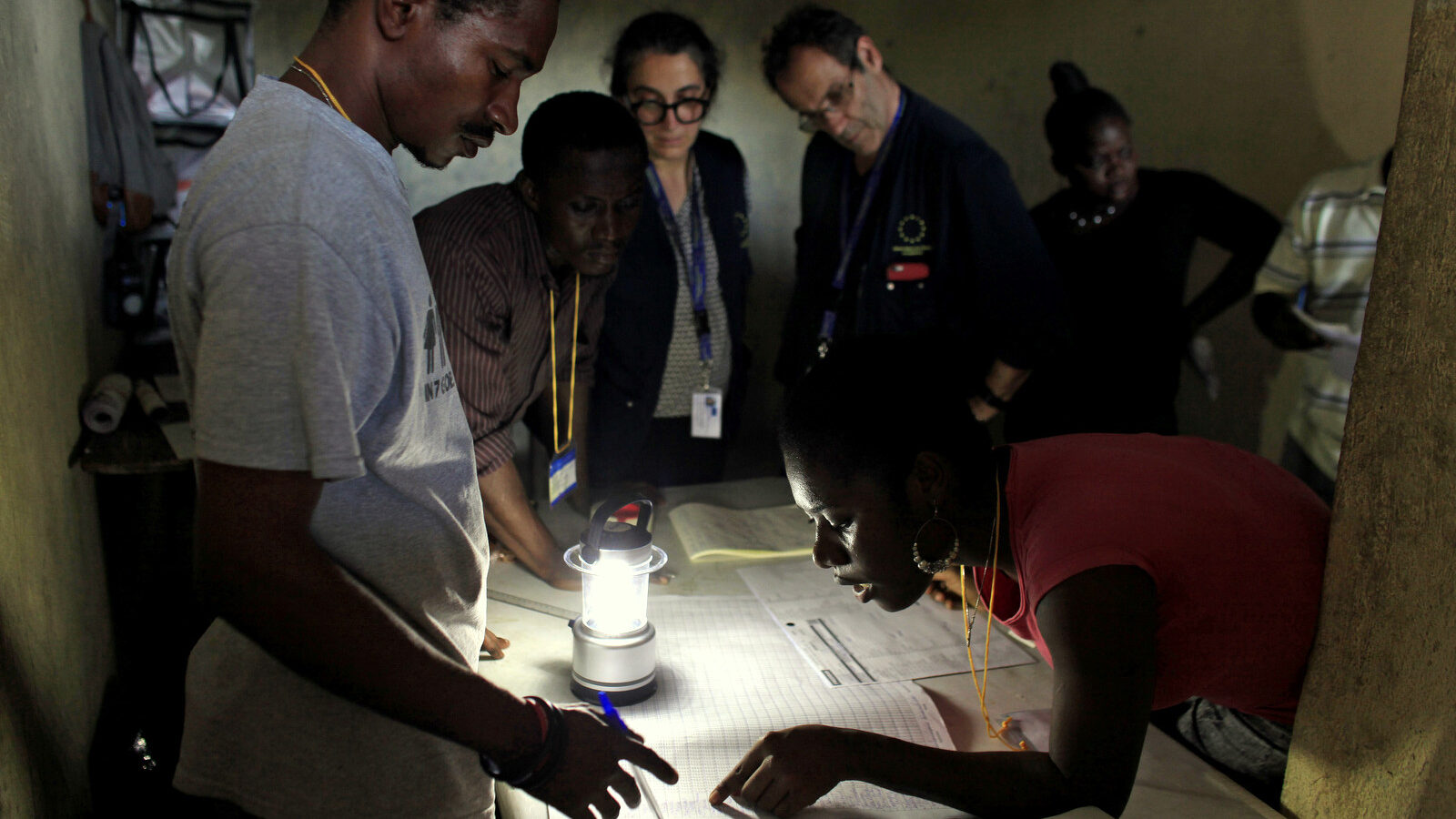 Members of the European Union Election Observation Mission observe electoral workers count ballots at a polling station at the end of the general elections, in Port-au-Prince, Haiti, Sunday, Oct. 25, 2015. The country held the first-round presidential vote Sunday along with balloting for numerous legislative races and local offices. (AP Photo/Ricardo Arduengo)