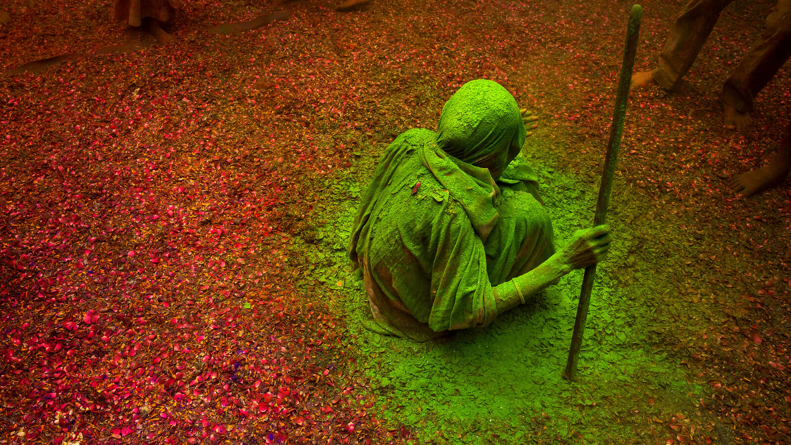 An Indian Hindu widow smeared with colors sits and watches others playing during Holi celebrations at the Gopinath temple, 180 kilometres (112 miles) south-east of New Delhi, India Monday, March 21, 2016. A few years ago this joyful celebration was forbidden for Hindu widows. Like hundreds of thousands of observant Hindu women they would have been expected to live out their days in quiet worship, dressed only in white, their very presence being considered inauspicious for all religious festivities. (AP Photo /Manish Swarup)