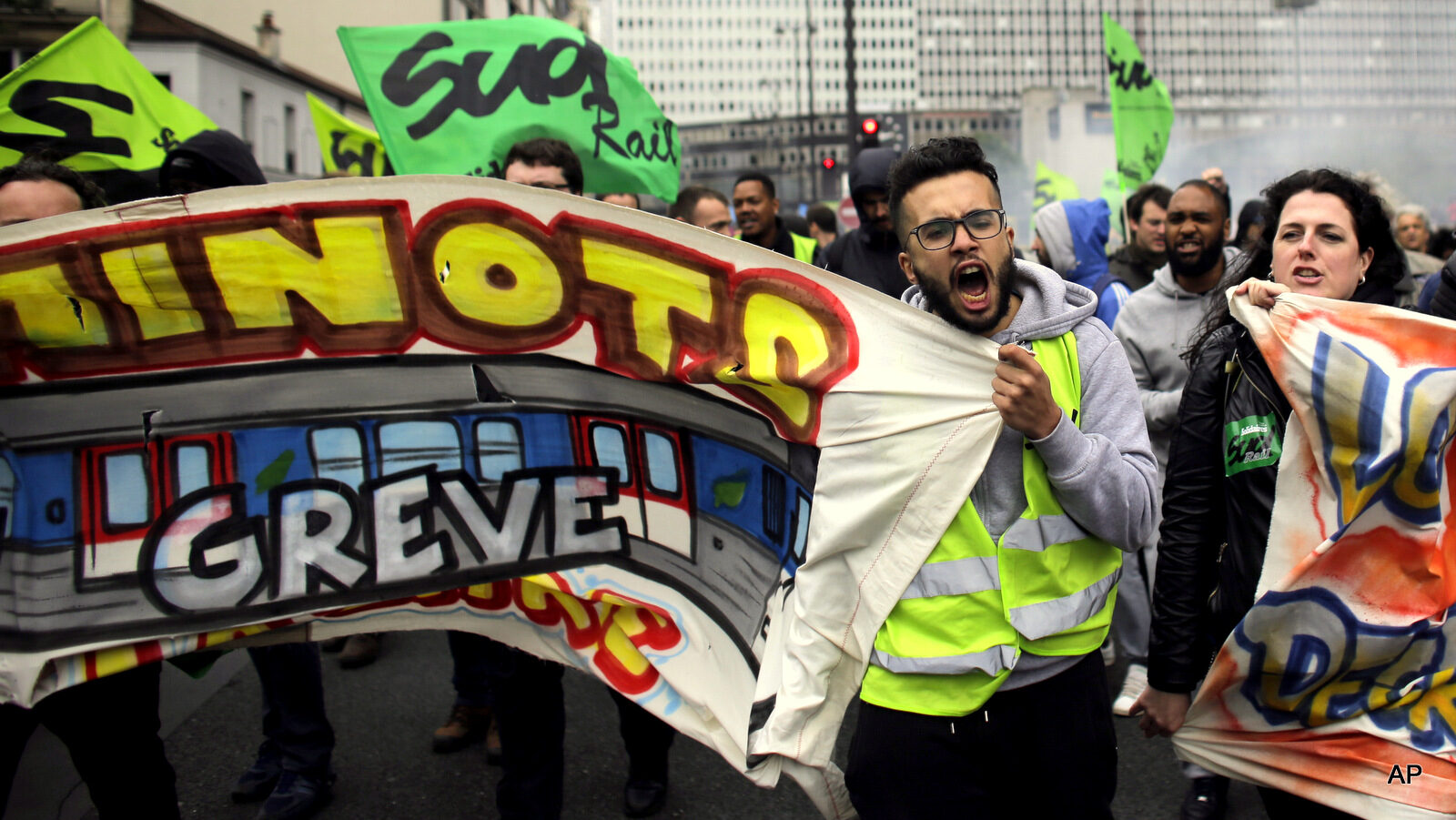 Labor union members on strike with a poster reading 'Railway workers from St Lazare station on strike!' shout slogans as they attend a demonstration against the French government and labor law reforms in Paris, Thursday, June 2, 2016. Workers are on strike at nearly all of France's nuclear plants and on the national rail service as part of months of protests over changes to labor protections.