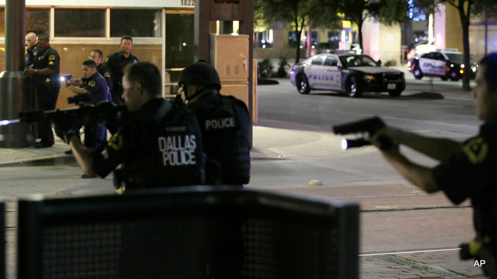 Dallas police move to detain a driver after several police officers were shot in downtown Dallas, Thursday, July 7, 2016. Snipers opened fire on police officers during protests Thursday night; some of the officers were killed, police said.