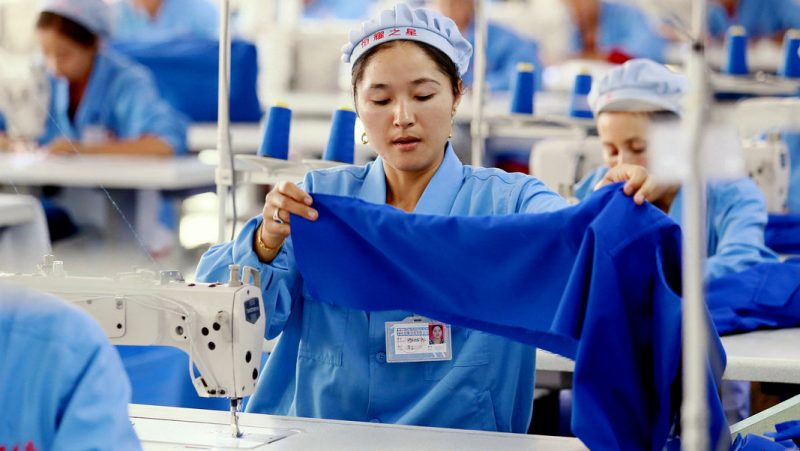 Chinese workers sew clothes at a garment factory in Wuqia town, Kuqa county, Aksu Prefecture, northwest China' class=