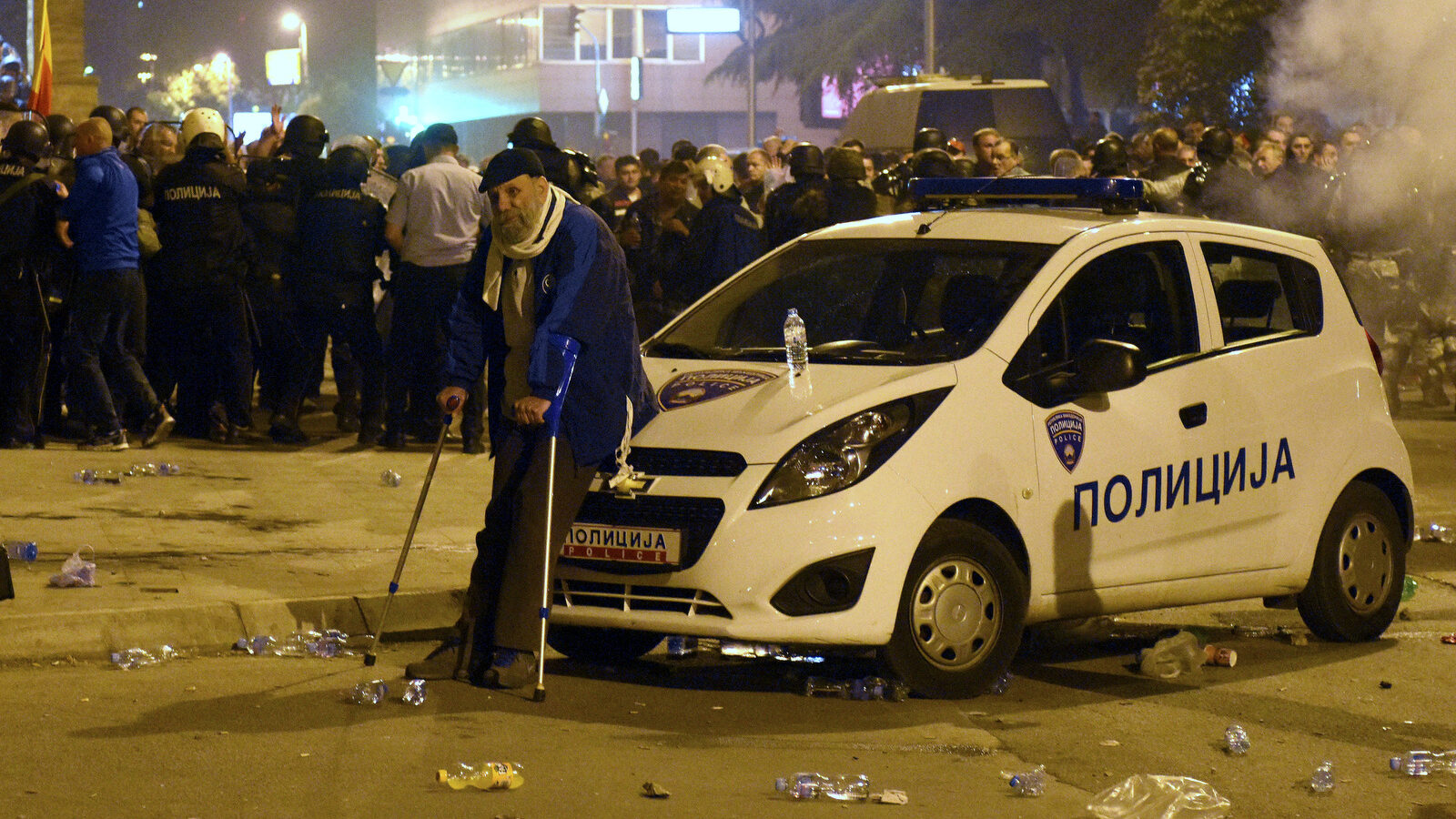 A man rests by a police car during clashes between protesters and the police in front of the parliament building in Skopje, Macedonia, Thursday, April 27, 2017. Chaos swept into Macedonia's parliament Thursday as demonstrators stormed the building and attacked lawmakers to protest the election of a new speaker despite a months-old deadlock in efforts to form a new government. (AP/Dragan Perkovski)