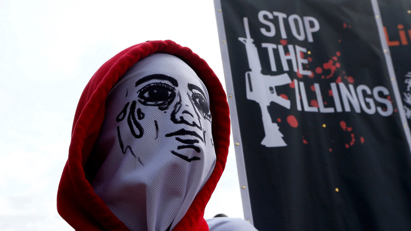 A masked protester stands next to a banner depicting thousands of victims of President Rodrigo Duterte's so-called war on drugs during a rally to coincide with his third State of the Nation Address, July 23, 2018, in Quezon city, Philippines. Bullit Marquez | AP