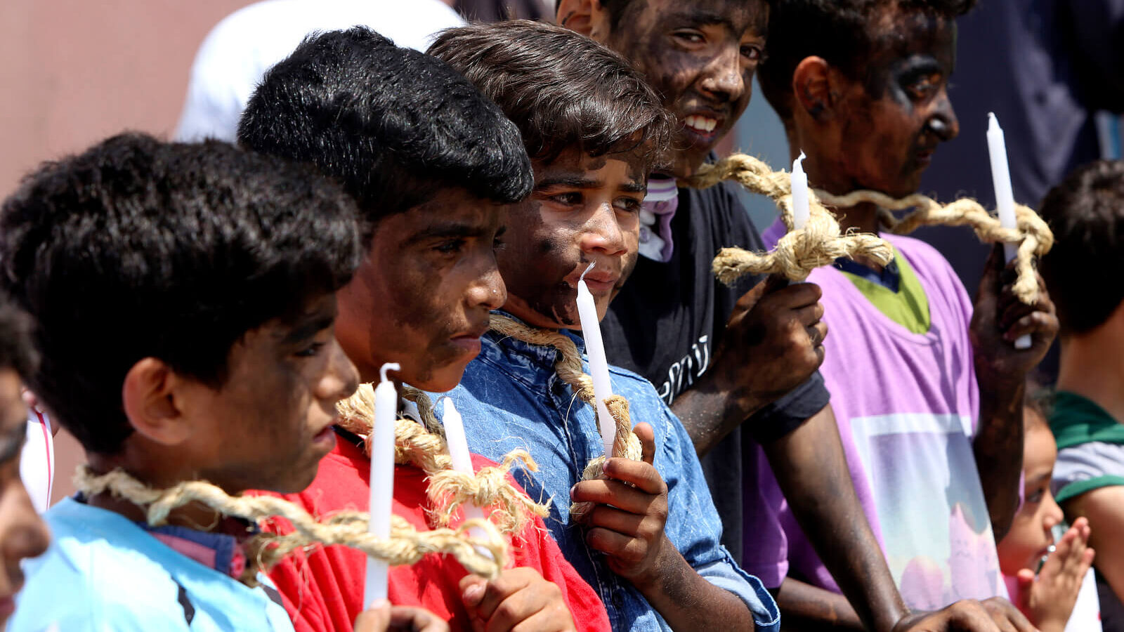 Children with their faces painted black hold candles and wear ropes around their necks during protest calling to end the Gaza siege at the Palestinian side of the Erez crossing border with Israel, in Beit Hanoun in the northern Gaza Strip, July 24, 2018. The protest was organized by the so-called Higher Committee for the Great Return March to highlight the suffering of children in Gaza due to an Israeli-Egyptian blockade and constant threat of violence. Adel Hana | AP